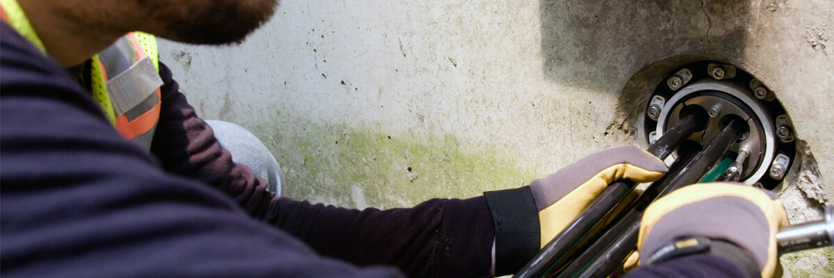 a worker in a vault installs a seal around some cables