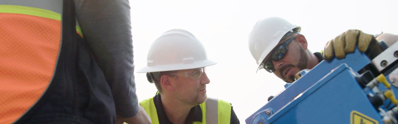 Two workers chat at a cable blowing worksite