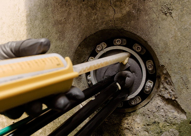 Polywater FST deployed into a conduit in a concrete wall. A Polywater Hauff Technik mechanical seals around the edge of the entrance.