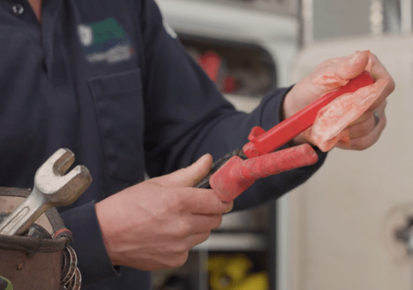 An electrical lineman cleaning his tools with a Polywater Grime-Away wipe.