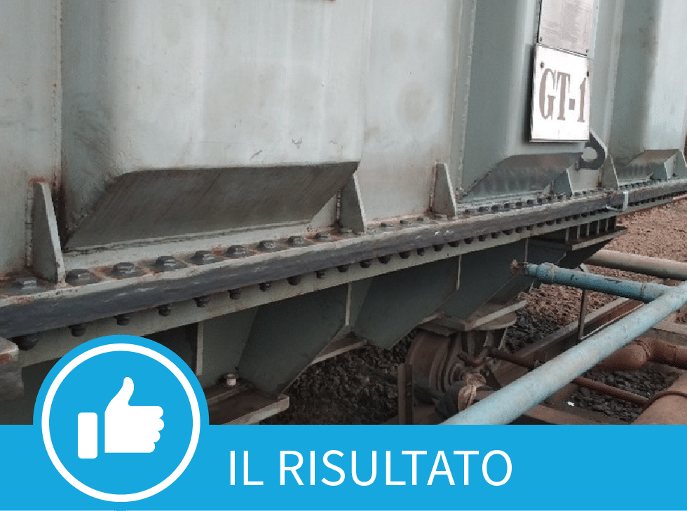 Un vecchio trasformatore elettrico verde/grigio con uno striscione blu nella parte inferiore dell'immagine che dice 