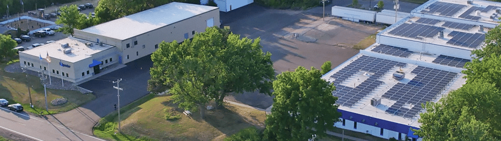 An overhead drone shot of Polywater's two buildings. The building on the right is covered in solar panels.